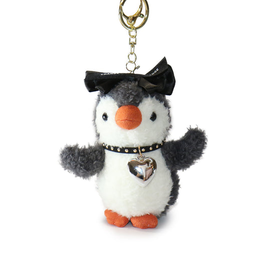 Plush penguin keychain with a black bow and heart charm on a white background