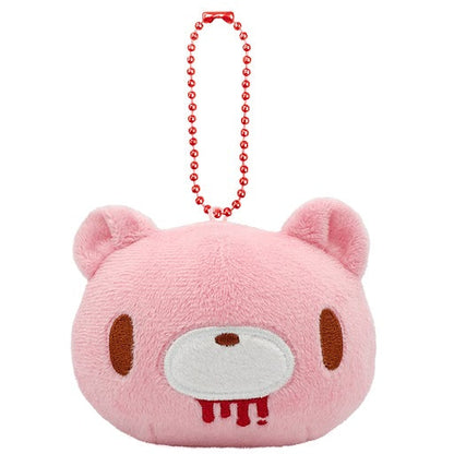 Pink plush keychain with a face design on a white background